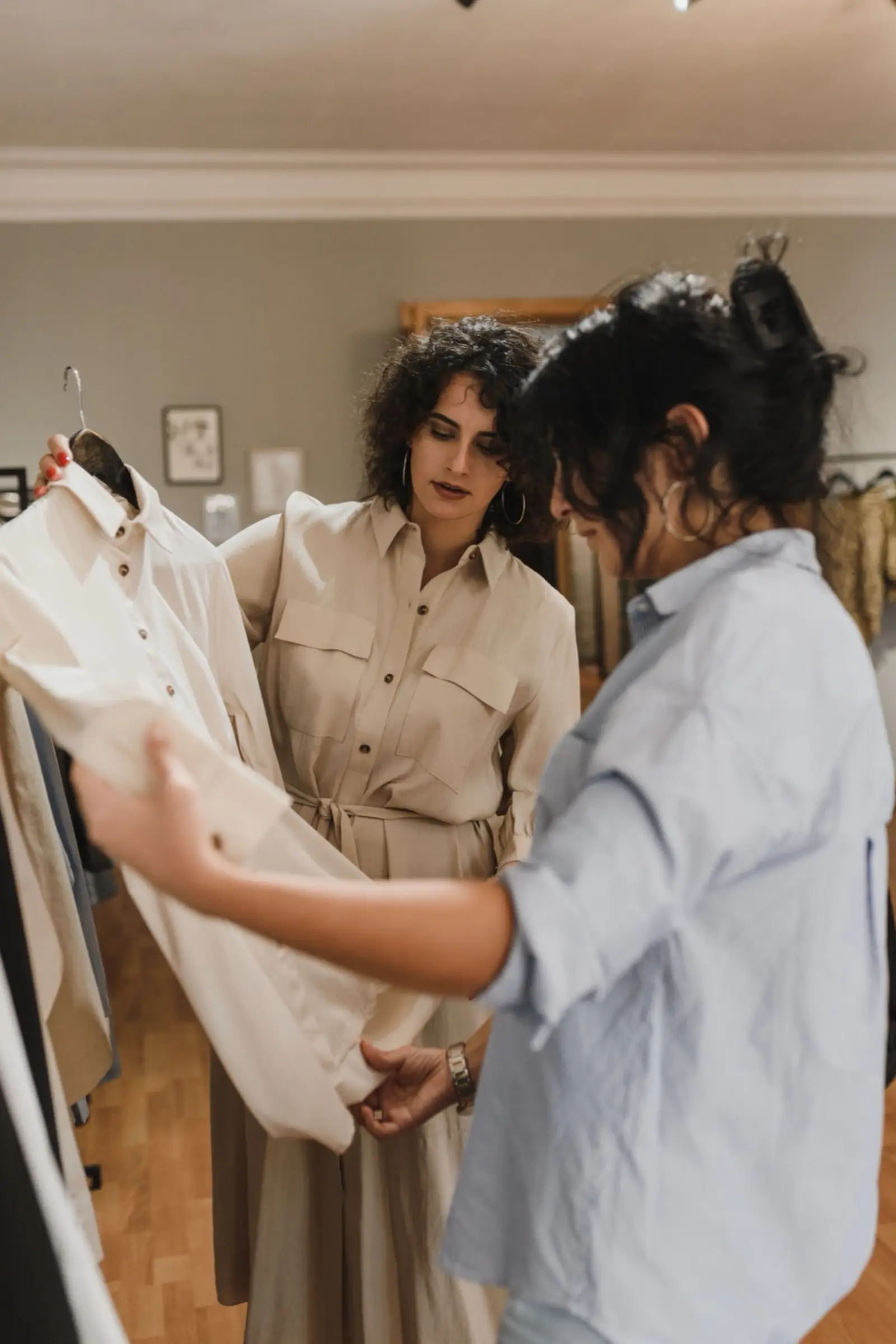 A boutique owner showing a garment to a customer