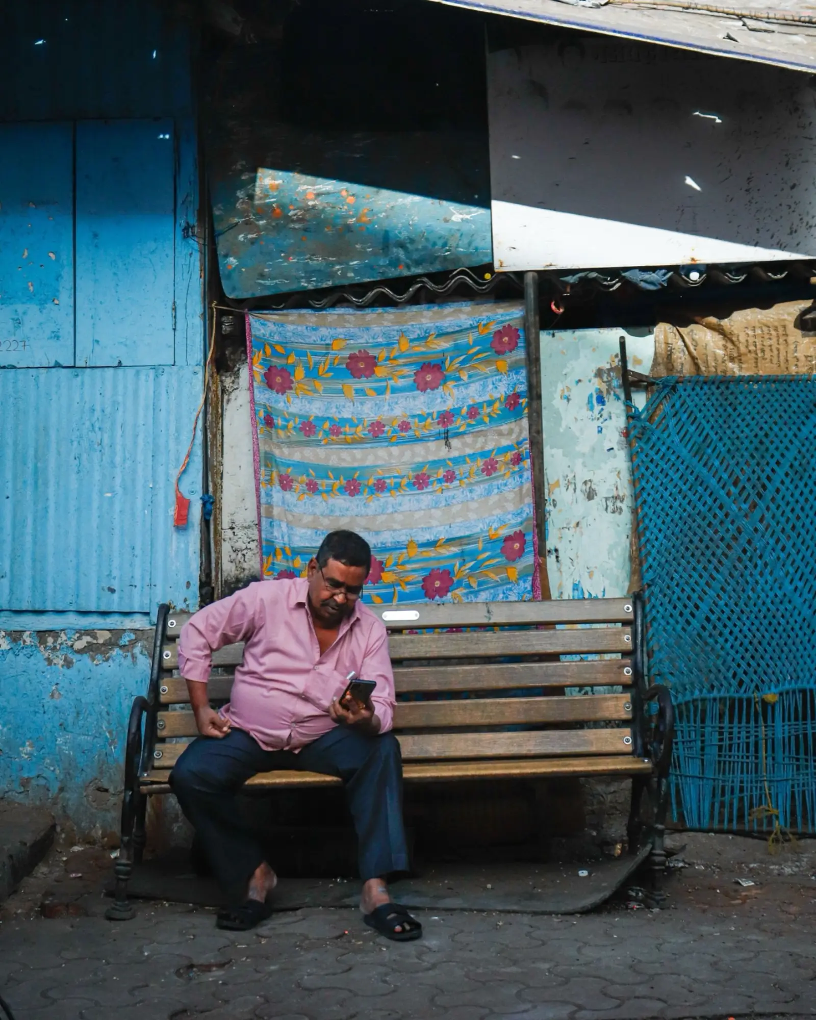 A shop owner on his phone at his textile stall